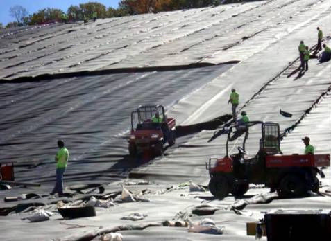 Photo of geosynthetics being installed on a landfill slope